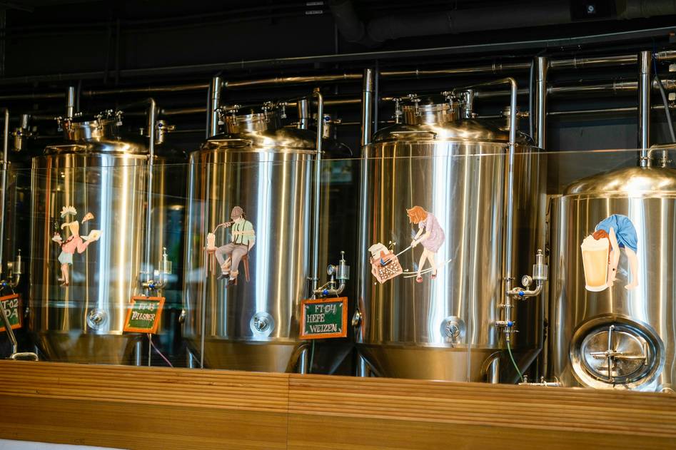 Brewer pouring organic beer into glass